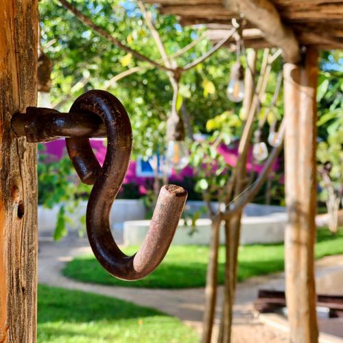 a rusty chain hanging from a wooden door at La Parcela Cunkal in Conkal