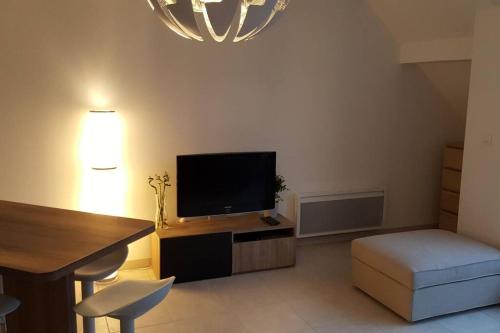 a living room with a flat screen tv and a desk at Kanoperoz-Plage de Trestraou in Perros-Guirec