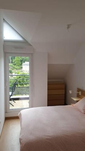 une chambre blanche avec un lit et une fenêtre dans l'établissement Kanoperoz-Plage de Trestraou, à Perros-Guirec