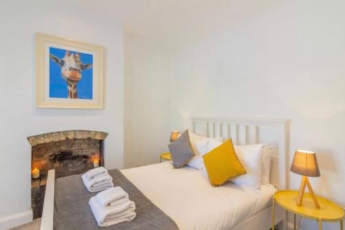 a bedroom with a bed and a fireplace with towels at Newly Refurbished Traditional Cottage Blackrock in Blackrock