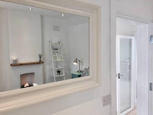 a mirror on a wall in a white room at Newly Refurbished Traditional Cottage Blackrock in Blackrock