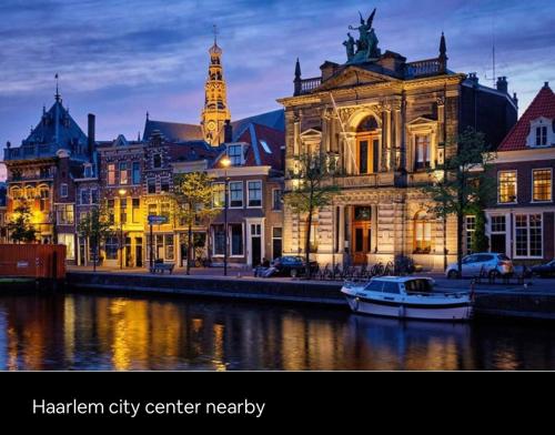 a city center at night with a boat in the water at Wellness bungalow with jacuzzi &sauna&private garden near Amsterdam in Vijfhuizen