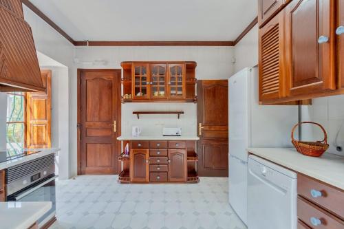 a kitchen with wooden cabinets and a counter top at Villa Casal Assis in Setúbal