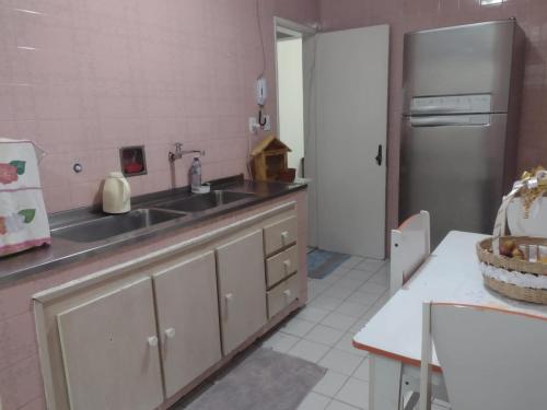 cocina con fregadero y nevera en Apartamento na Graça próximo a Barra, Hospitais e UFBA, en Salvador