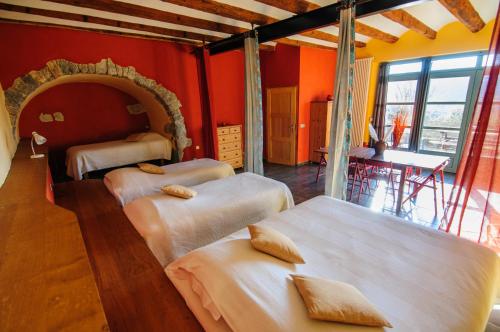 BrissacにあるChâteau Le Villarelの赤い壁のベッドルーム1室(ベッド3台付)