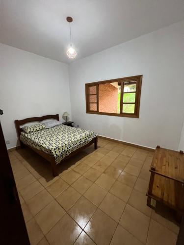 a bedroom with a bed and a window at Casa de Campo do Caminho da Fé in Águas da Prata