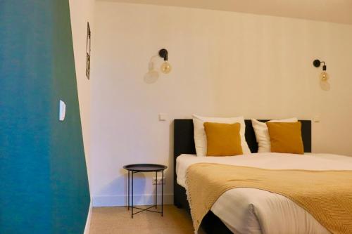 a bedroom with two beds with yellow pillows and a stool at Boetiek hotel Azul in Goedereede