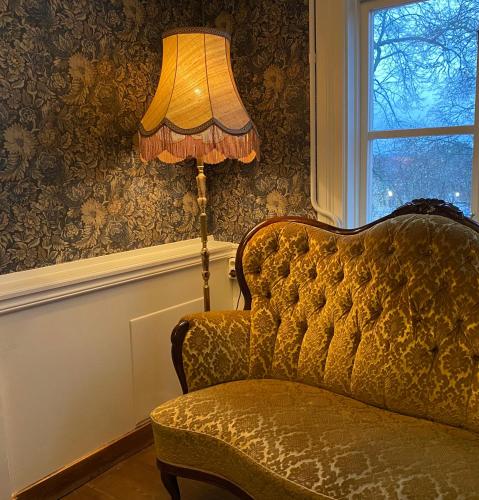 a lamp sitting next to a chair next to a window at Kinna Bed & Breakfast in Kinna