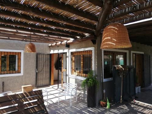 a patio with chairs and a building with a roof at El descanso, zona de bodegas in Ciudad Lujan de Cuyo