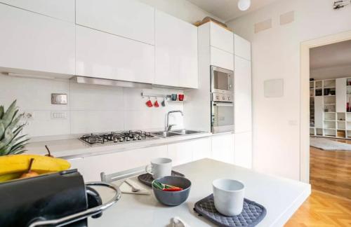 a kitchen with white cabinets and a counter top at Cicerone Apartment in Rome