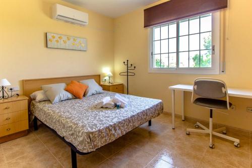ベンドレルにあるCatalunya Casas Cozy Costa Dorada with private pool, 3km to beach!のベッドルーム1室(ベッド1台、デスク、椅子付)