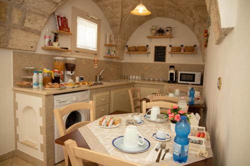 uma cozinha com mesa e cadeiras e uma cozinha com lavatório em La Corte dei Sogni em Taviano