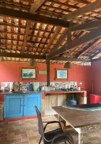 una cucina con armadi blu e tavolo in legno di Aldeia de Camburi a Camburi