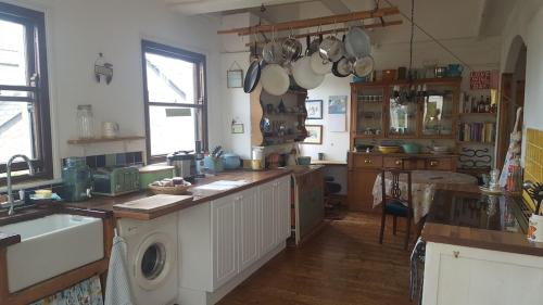 cocina con fregadero y lavadora en Stunning house with sea views and parking, Newlyn Penzance en Penzance