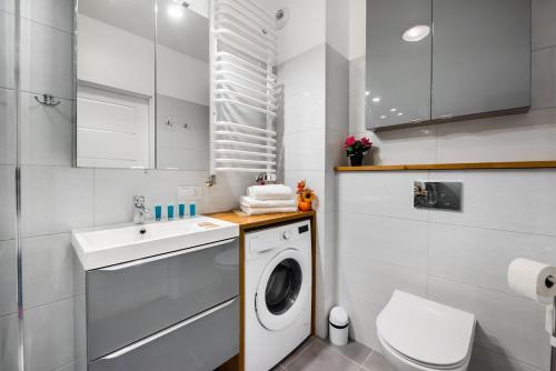 a bathroom with a washing machine and a sink at Metro Bemowo Colourful Apartment in Warsaw