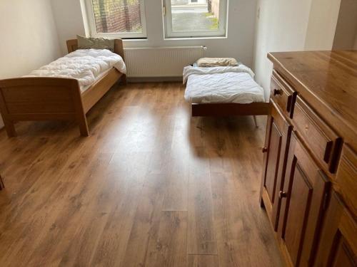 a room with two beds and a wooden floor at Einfaches grosse geräumiges Wohnung für Monteuren in Dortmund