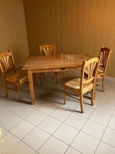 a wooden table with four chairs and a wooden table and chairsktop at Einfaches grosse geräumiges Wohnung für Monteuren in Dortmund