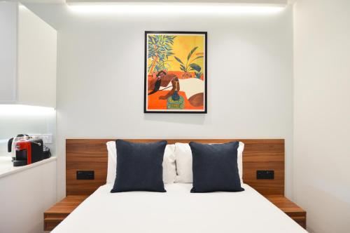 a bedroom with a white bed and a painting on the wall at West Hampstead Serviced Apartments in London