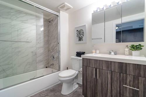 uma casa de banho com um WC, um lavatório e um chuveiro em McCormick Place Huge 2b-2b Loft with optional parking that sleeps up to 6 em Chicago