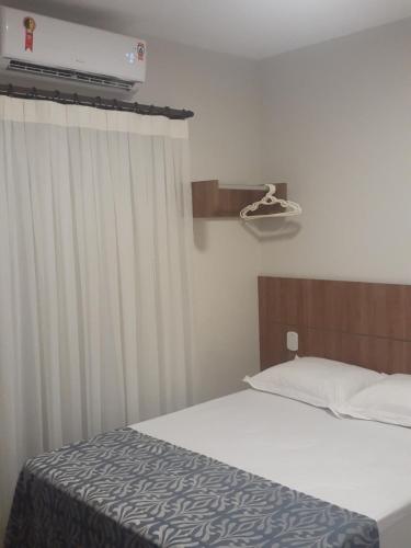 a bedroom with a bed and a window with a heater at Lençóis Confort Barreirinhas in Barreirinhas