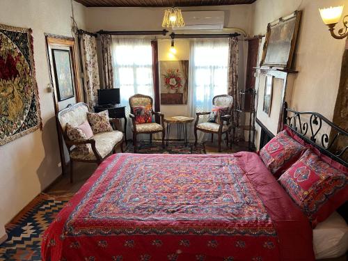 a bedroom with a bed and chairs and a table at Mystic Konak in Selcuk