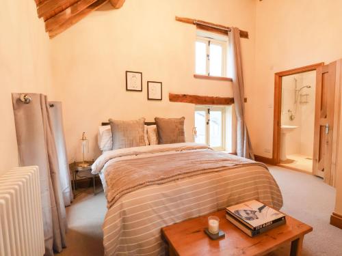 1 dormitorio con cama y mesa de madera en High Trees, en Sandbach