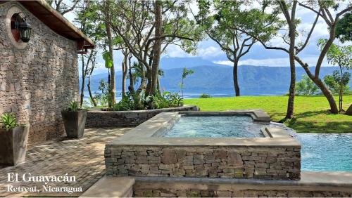a hot tub in a stone wall next to a building at El Guayacán in Valle la Laguna