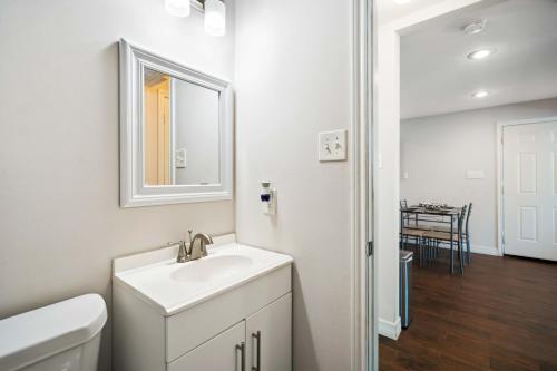 ein weißes Badezimmer mit einem Waschbecken und einem Spiegel in der Unterkunft Stunning & Vibrant APT 7 Min From TX Med Center in Houston