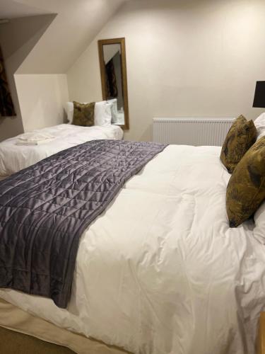 a bedroom with two beds and a mirror at The Aberlour Hotel in Aberlour