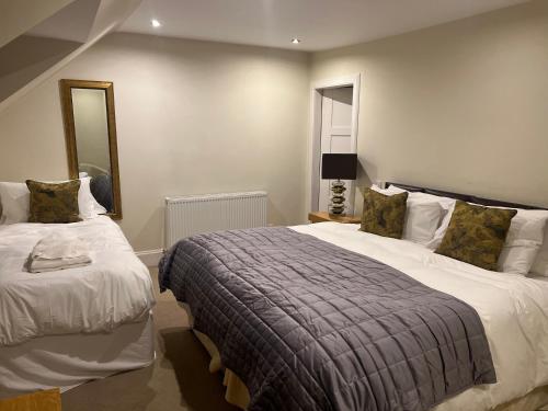 a bedroom with two beds and a mirror at The Aberlour Hotel in Aberlour