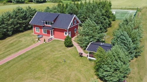 an overhead view of a red house with solar panels on it at Villa Ievynė in Paežeriai