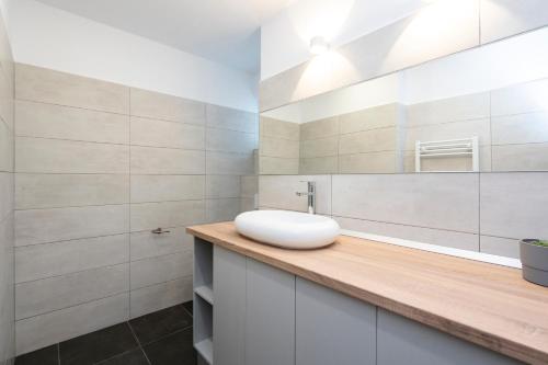 La salle de bains est pourvue d'un lavabo et d'un miroir. dans l'établissement Sapphire Apartment In The Center Of Bucharest, à Bucarest
