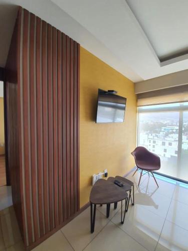 um quarto com uma cadeira, uma mesa e uma janela em Oasis em Pachuca de Soto