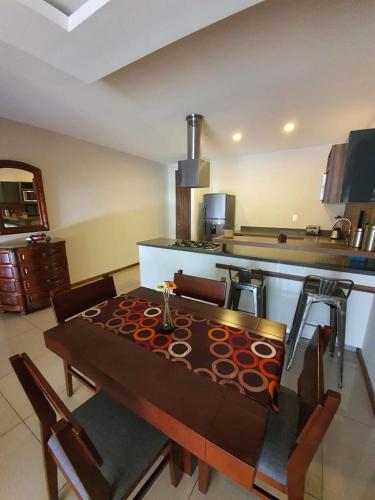 uma cozinha com uma mesa de madeira com cadeiras e um balcão em Oasis em Pachuca de Soto