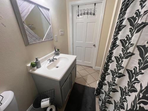 a bathroom with a sink and a shower curtain at Simplicity Stays NOLA in New Orleans