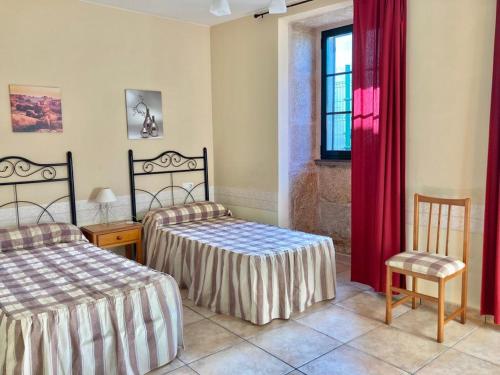 LouroにあるCasa do Campo Louroのベッドルーム1室(ベッド2台付)、赤いカーテン付きの窓が備わります。