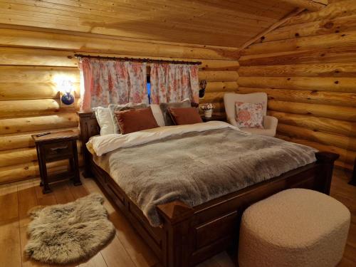 een slaapkamer met een bed in een blokhut bij Troya Chalets in Baba Stana