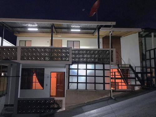 een huis 's nachts met een balkon en verlichting bij Hotel del Ferrocarril in Quetzaltenango