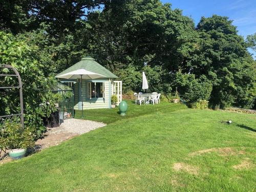 a gazebo with a table and chairs in a yard at The Old Deer House in Bodmin