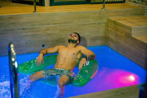 un hombre en una piscina con una tabla de surf en Orei Private Suites "Adult Only", en Trujillo