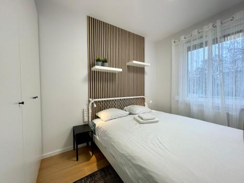 Un dormitorio con una cama grande y una ventana en Torpo Apartment with parking en Toruń