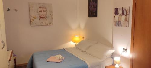 MiazzinaにあるCà Pinottaのベッドルーム1室(ベッド1台、帽子、ランプ2つ付)