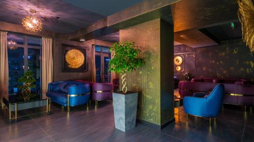 a lobby with purple chairs and a potted plant at Onyx City Center in Tbilisi City