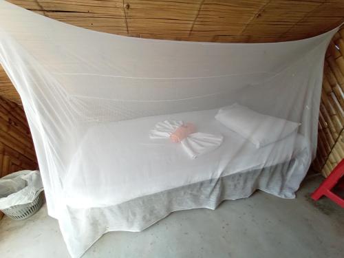 a bed with white sheets and a bow on it at Mirador Valle de la Tatacoa in Villavieja