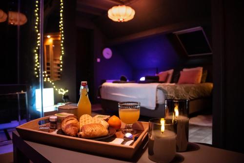 - un plateau de pain et de jus d'orange sur une table dans la chambre dans l'établissement PAUSE NATURE SORBAIS Chambre avec SPA, SAUNA, STREAMING et arrivée autonome, à Sorbais