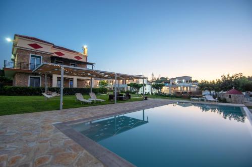 a swimming pool in front of a house at Omega Estate Resorts in Kipseli