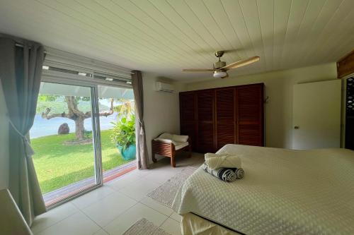 una camera con un letto e una grande porta scorrevole in vetro di Villa Ohana - Deluxe Villa w Private Beachfront a Otumai