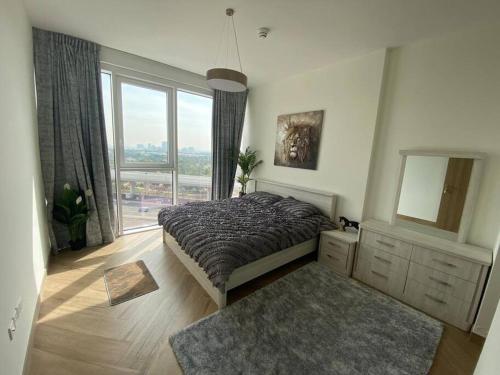 a bedroom with a bed and a large window at Feel home ! Away from home in Dubai