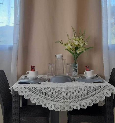 a table with a white table cloth and a vase of flowers at De Hagan Transient Baguio City in Baguio