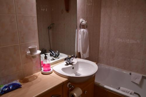 a bathroom with a sink and a bath tub at Entire Niche in Hildenborough